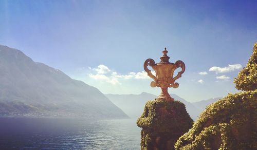 Statue by mountain against sky