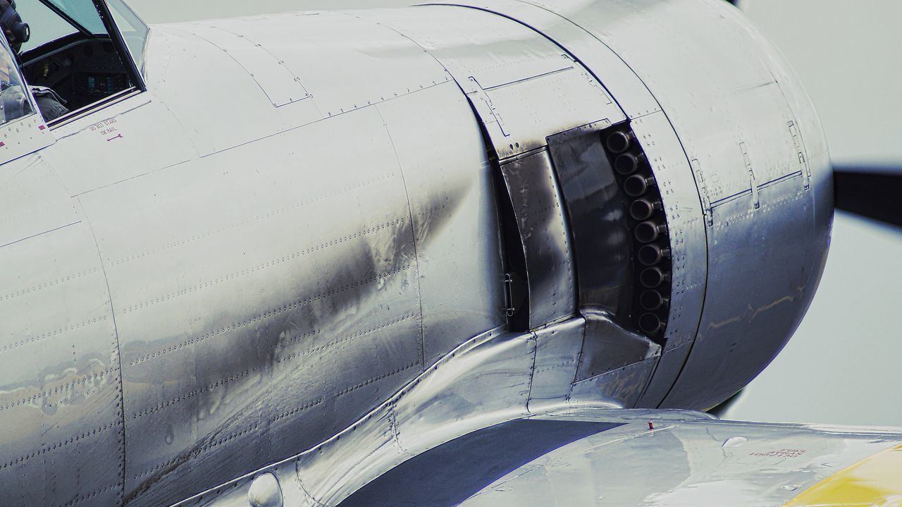 CLOSE-UP OF AIRPLANE FLYING OVER AIRPORT RUNWAY