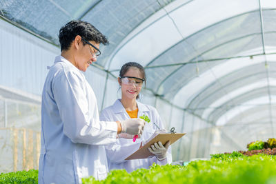 Man and woman working in greenhouse