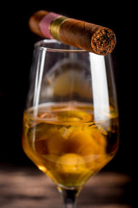 Close-up of whiskey in glass with cigar