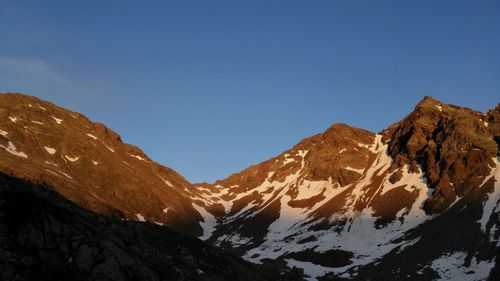 Scenic view of snowcapped mountains against clear blue sky