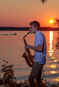 Side view of man standing at sunset