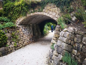 Rear view of man walking on footpath