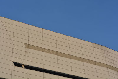 Low angle view of modern building against clear blue sky