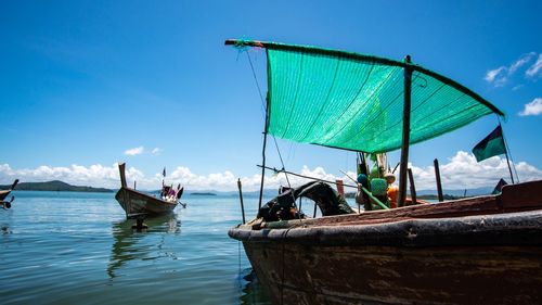 People on boat in sea against blue sky