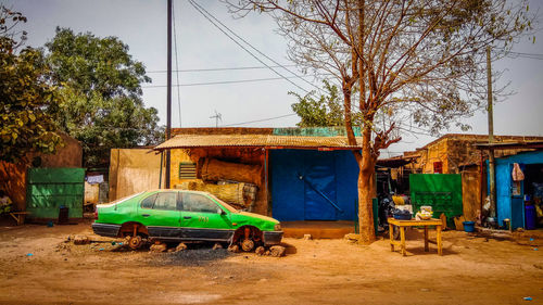 View of abandoned car on street against buildings