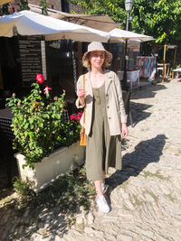 Portrait of woman standing against plants