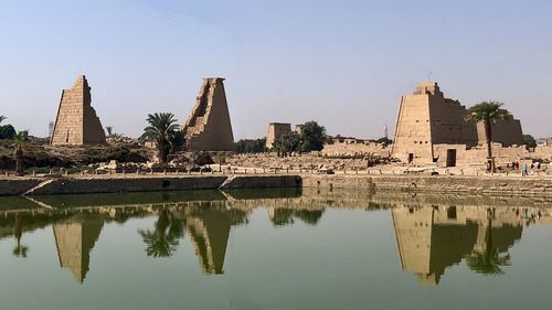 Reflection of temple in lake against sky