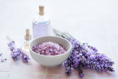 Spa products and lavender flowers on a pink tile background. aromatherapy lavender bath salt 