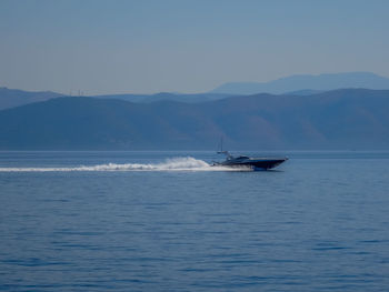 Boat sailing on sea against clear sky