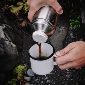 Cropped hand pouring coffee into mug