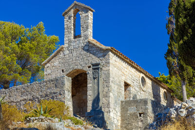 Low angle view of old building against clear blue sky