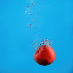 Close-up of cherries on water against blue background