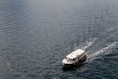 Perast, montenegro, quick red white boat floating in the bay with tourists 