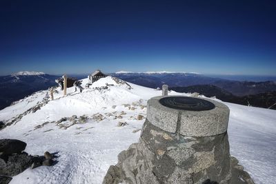 Scenic view of snowcapped mountains against clear blue sky