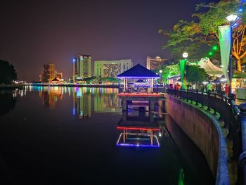 Illuminated buildings at waterfront in city