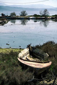 Abandoned boat in sea against sky