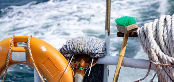 Close-up of rope tied to wooden post in sea during winter