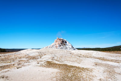 Scenic view of mountain against blue sky