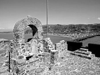 Built structure by sea against sky