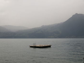 Wooden plank in the sea with mountains in background