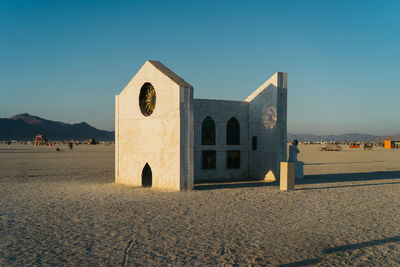 Built structure on beach against clear blue sky