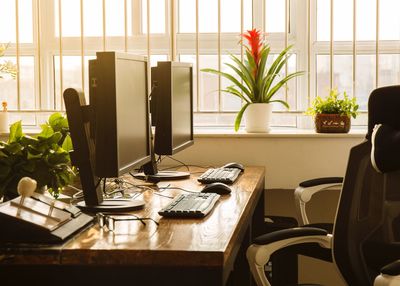 Computers on table by window at office