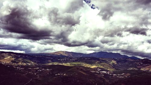 Scenic view of mountains against cloudy sky