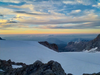 Scenic view of snowcapped mountains against sky during sunset