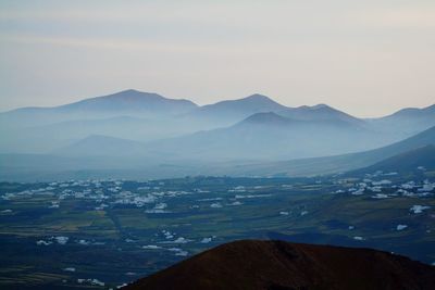 Scenic view of misty landscape and mountains against sky at lanzarote