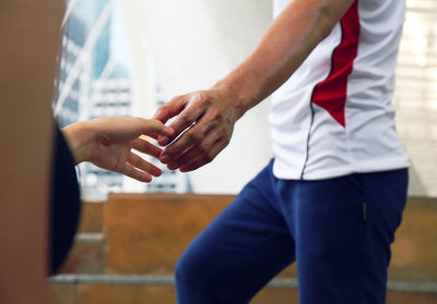 Midsection of couple holding hands