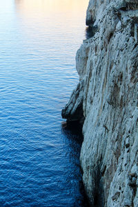 Rock formation in sea against sky