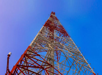 Low angle view of communications tower against clear blue sky