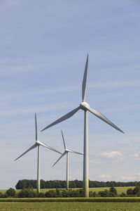 Wind turbines on land against sky