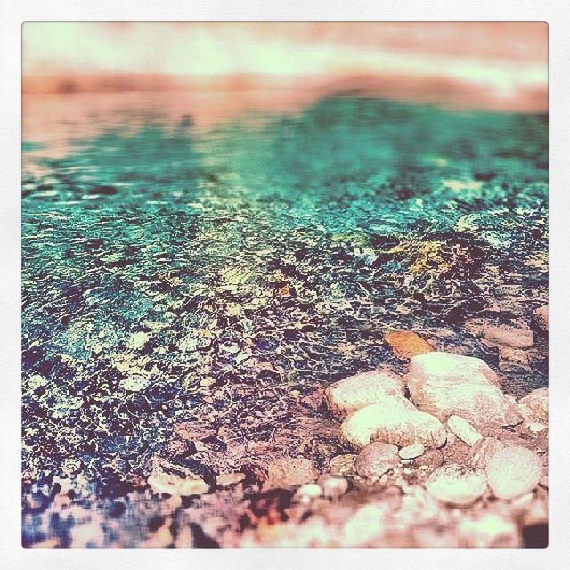 transfer print, auto post production filter, beach, water, nature, selective focus, tranquility, close-up, surface level, pebble, sand, shore, stone - object, outdoors, no people, beauty in nature, high angle view, tranquil scene, wet, day