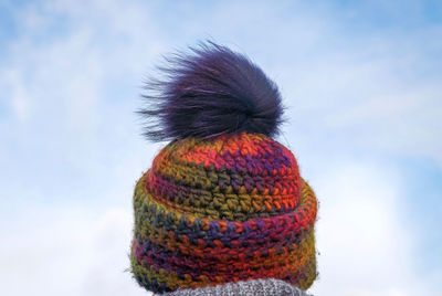 Rear view of person wearing knit hat against sky