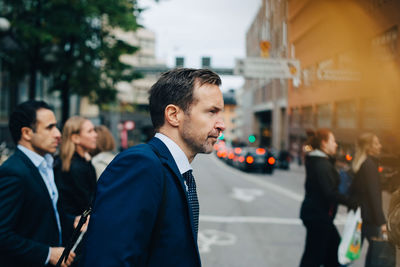 Side view of mature business colleagues walking on street in city