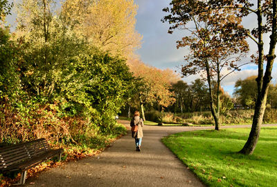Rear view of woman walking on field