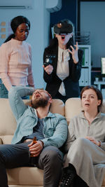 Smiling colleagues playing video game at office