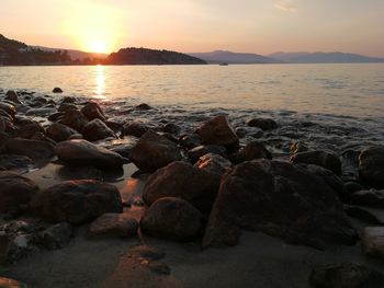 Rocks on shore during sunset