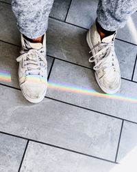 Low section of man standing on tiled floor