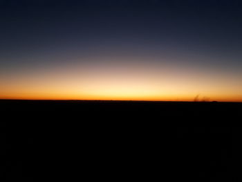 Silhouette landscape against clear sky during sunset