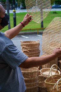 Midsection of man holding ice cream while standing in basket