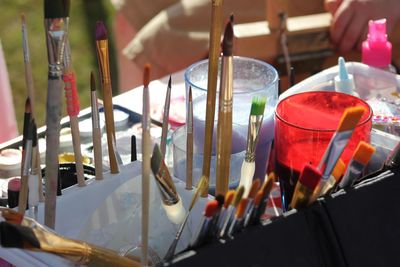Close-up of paint brushes and glass on table