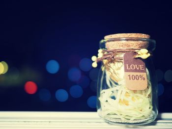 Close-up of glass jar on table against black background