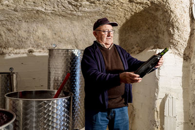 Portrait of man standing against wall