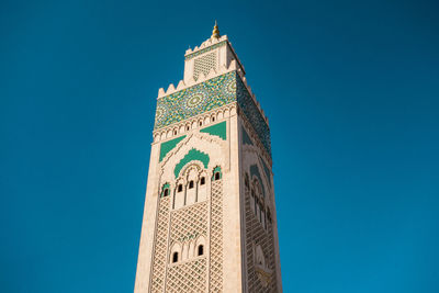 Low angle view of mosque against clear blue sky