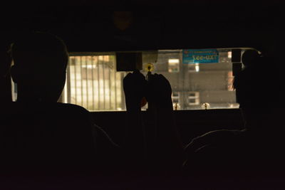 Rear view of silhouette people sitting in bus