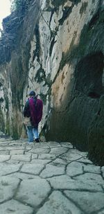 Rear view of woman walking on footpath