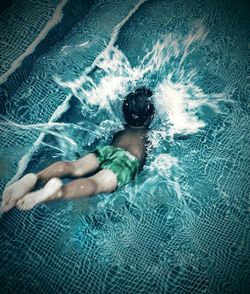 High angle view of boy diving into swimming pool